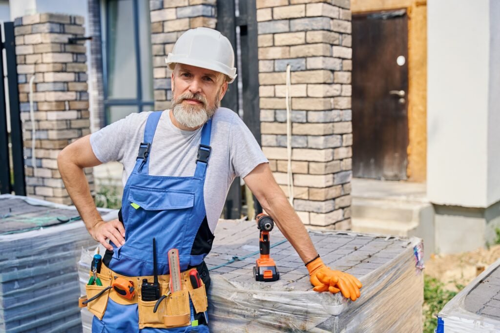 Confident bricklayer posing for camera on construction site